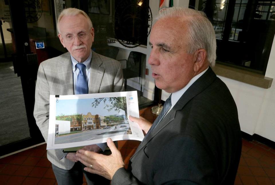 El entonces alcalde de Miami-Dade Carlos Giménez (derecha), y Michael Spring, director del Departamento de Asuntos Culturales del condado, con una representación de un renovado Coconut Grove Playhouse en 2019 tras reunirse con el alcalde de Miami, Francis Suárez.
