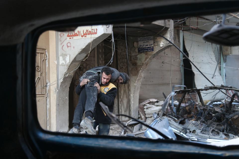 <p>Ein Helfer der Weißhelme der oppositionellen syrischen Zivilverteidigung bringt einen Verwundeten in der Stadt Hamouriyah in Sicherheit. (Bild: ABDULMONAM EASSA/AFP/Getty Images) </p>