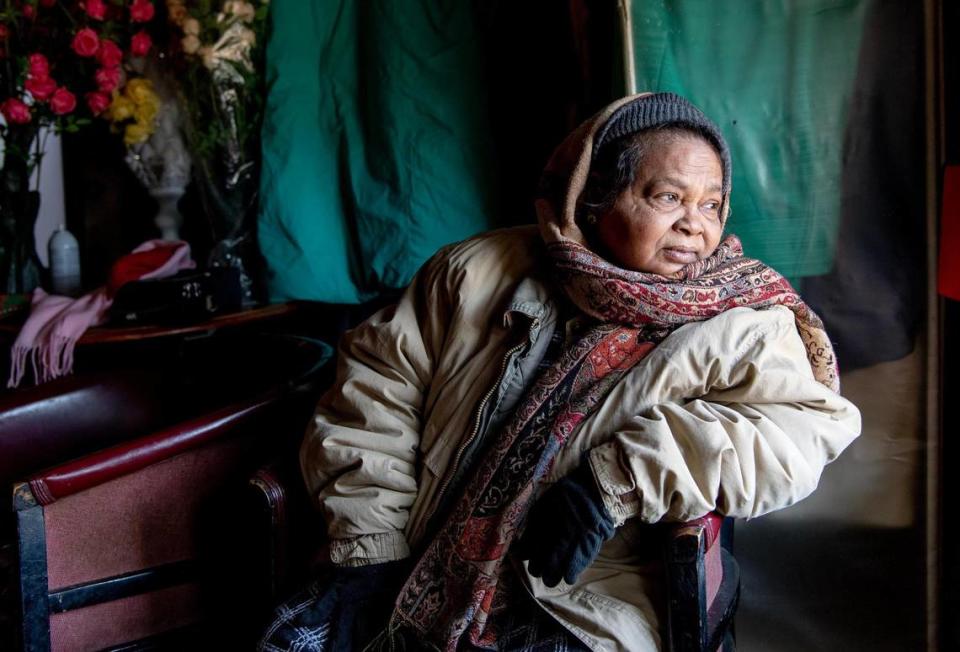 A woman, bundled up in winter clothing, looks out from her apartment on Jan. 23 in Kansas City. The multi-family housing unit had been without heat for days.