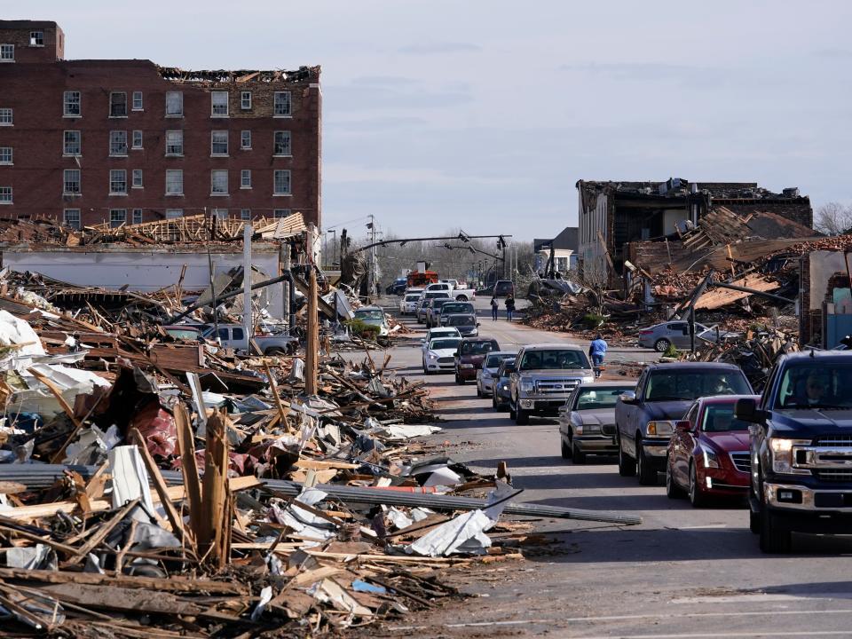 People survey damage from a tornado is seen in Mayfield, Ky., on Saturday, Dec. 11, 2021 (AP)