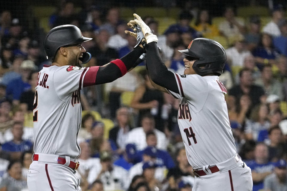 Arizona Diamondbacks' Gabriel Moreno, right, is congratulated by Lourdes Gurriel Jr. after hitting a two-run home run during the fourth inning of a baseball game against the Los Angeles Dodgers Monday, Aug. 28, 2023, in Los Angeles. (AP Photo/Mark J. Terrill)