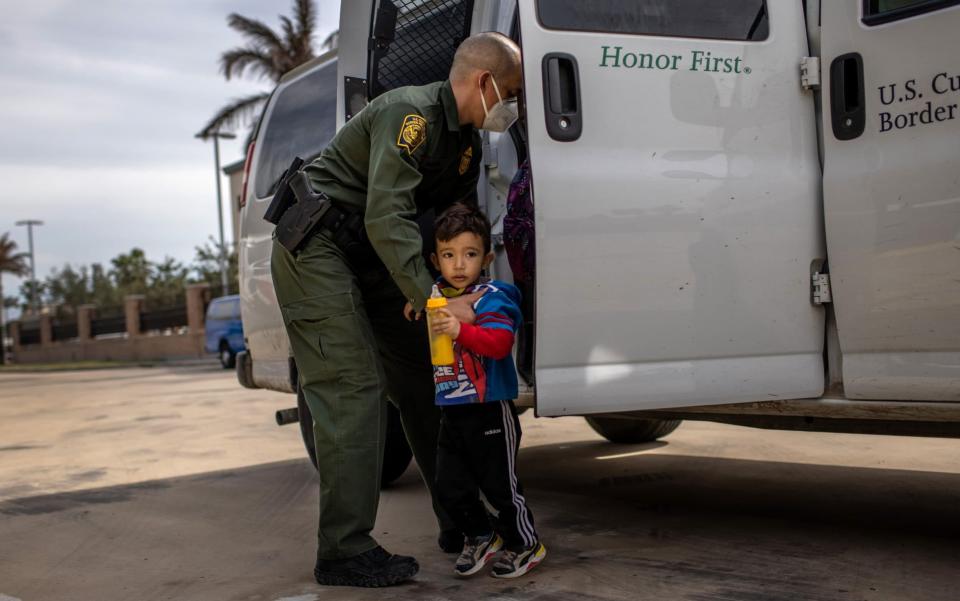 A US Border Patrol agent delivers a young asylum seeker and his family to a bus station in Brownsville, Texas - John Moore /Getty Images North America 