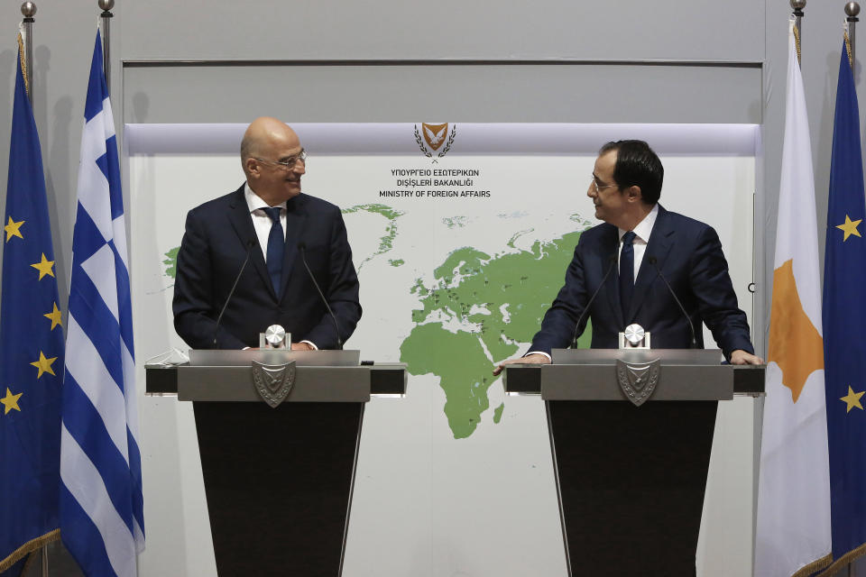 Greek Foreign Minister Nikos Dendias, left, and his Cyprus counterpart Nicos Christodoulides talk to the media during a press conference at the foreign ministry house in divided capital Nicosia, Cyprus, Dec. 4, 2020. Dendias and Christodoulides were meeting to coordinate their course of action ahead of a summit of European Union leaders next week to decide on a Turkish hydrocarbons search in waters where Cyprus and Greece claim exclusive rights and which EU officials have called " provocative"and "unlawful." (AP Photo/Petros Karadjias, Pool)