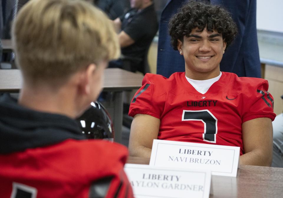 Liberty high quarterback Navi Bruzon shares a laugh during the Arizona Interscholastic Association high school state football championship media day in Phoenix on Nov. 29, 2023.