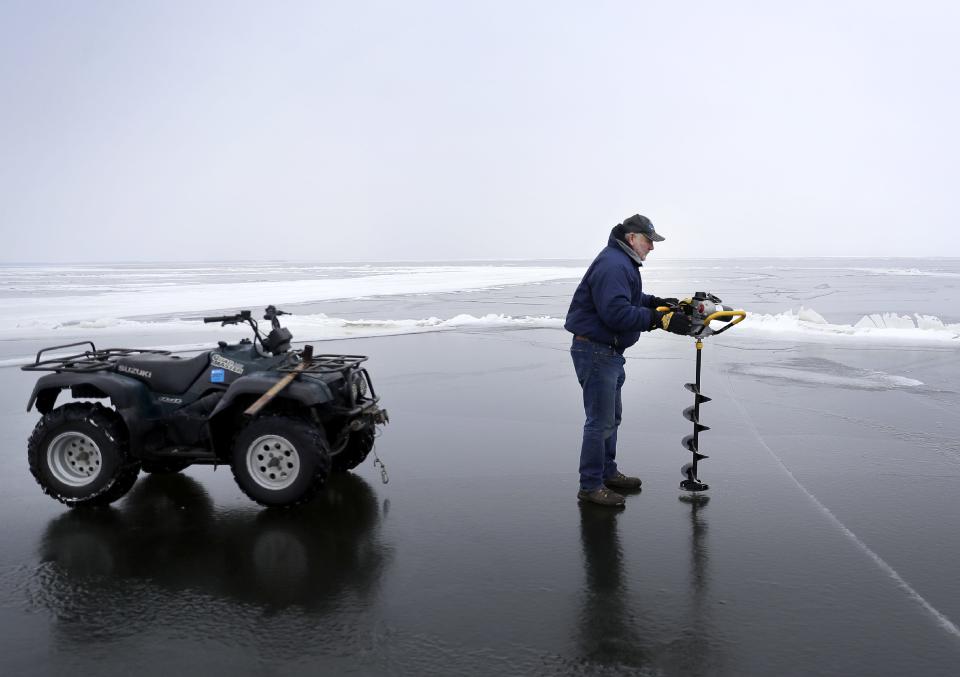 Don Herman, owner of SUNK? Dive & Ice Service, checks ice quality and thickness on Lake Winnebago January 2022 in Oshkosh. After the ice is deemed safe, plows and pine trees will be used to create and mark roadways and hazards for those venturing on to the ice.