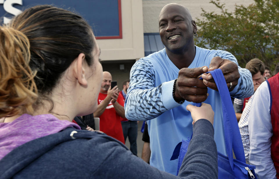 Charlotte Hornets owner Michael Jordan greets people and hands out food for Thanksgiving to members of the community in Wilmington, N.C., Tuesday, Nov. 20, 2018. (AP Photo/Gerry Broome)