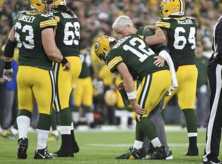 Sep 9, 2018; Green Bay, WI, USA; Green Bay Packers quarterback Aaron Rodgers (12) is helped off the field after he was sacked in the second quarter during the game against the Chicago Bears at Lambeau Field. Mandatory Credit: Benny Sieu-USA TODAY Sports