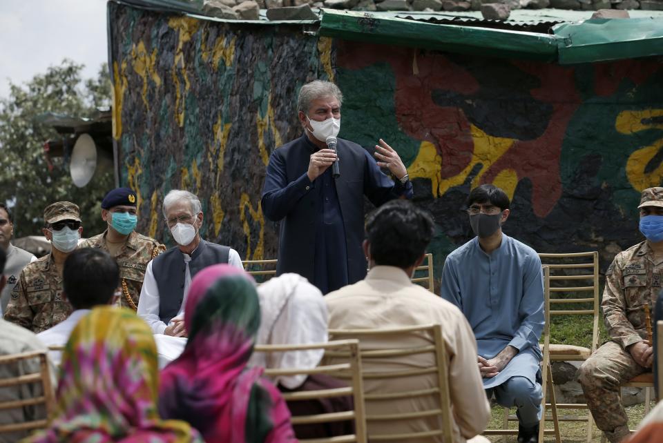 Pakistan's Foreign Minister Shah Mahmood Qureshi, center, addresses to villagers while Defense Minister Pervez Khattak, third left, looks on during their visit to forward area post along a highly militarized frontier in the disputed region of Kashmir, in Chiri Kot sector, Pakistan, Monday, Aug. 3, 2020. The region's top Pakistani military commander briefed ministers about Indian cease-fire violations in Kashmir, which is split between Pakistan and India and claimed by both in its entirety. (AP Photo/Anjum Naveed)