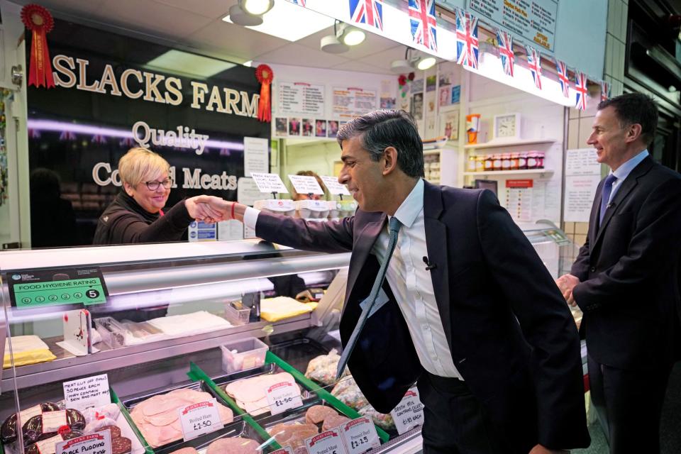 Rishi Sunak and Chancellor Jeremy Hunt meet stall holders as they visit Accrington Market Hall (REUTERS)