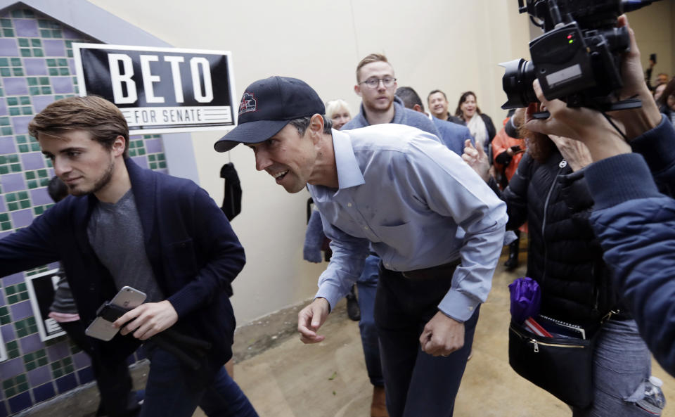 Democratic U.S. Senate candidate Beto O'Rourke, center, ducks through the rain as he arrives for rally, Monday, Oct. 15, 2018, in San Antonio. O'Rourke is taking a sharper tone in his campaign heading into the final scheduled debate with Republican Sen. Ted Cruz. (AP Photo/Eric Gay)