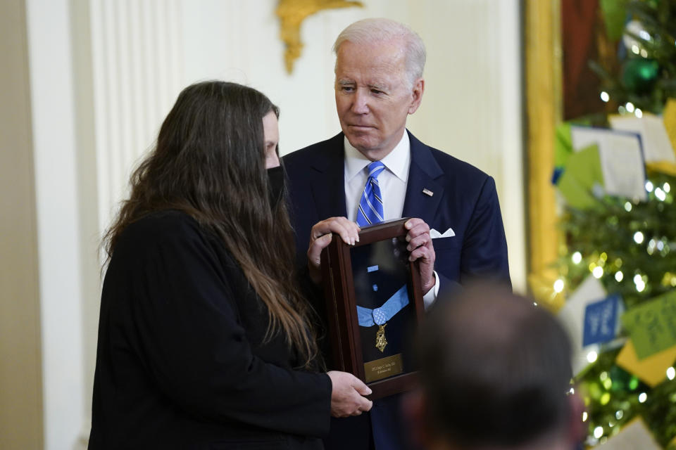 President Joe Biden presents the Medal of Honor to Army Sgt. First Class Alwyn C. Cashe for his actions in Iraq on Oct. 17, 2005, as his widow Tamara Cashe accepts the posthumous recognition during an event in the East Room of the White House, Thursday, Dec. 16, 2021, in Washington. (AP Photo/Evan Vucci)