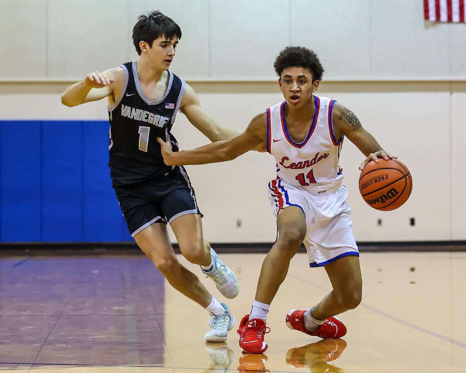 Leander guard JJ Desir fends off Vandegrift's Lucas Semelsberger during the Lions' 48-34 win Tuesday at Leander High School. Leander is off to a 7-3 start after missing last year's postseason.