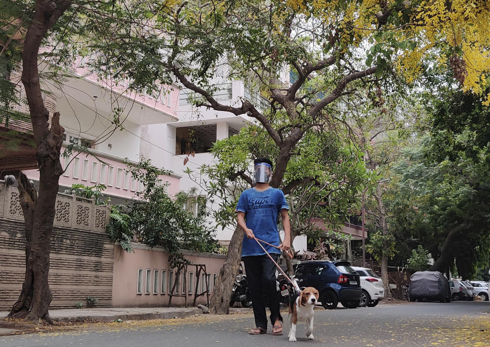 Abhimanyu Chakravorty, son of 73-year-old Prabir Chakravorty, a COVID-19 survivor, takes his dog for a stroll outside his home in New Delhi, India on May 17, 2021. Prabir Chakravorty, the family patriarch and widower, a construction executive was treated at home for the coronavirus. (AP Photo/Aniruddha Ghosal)