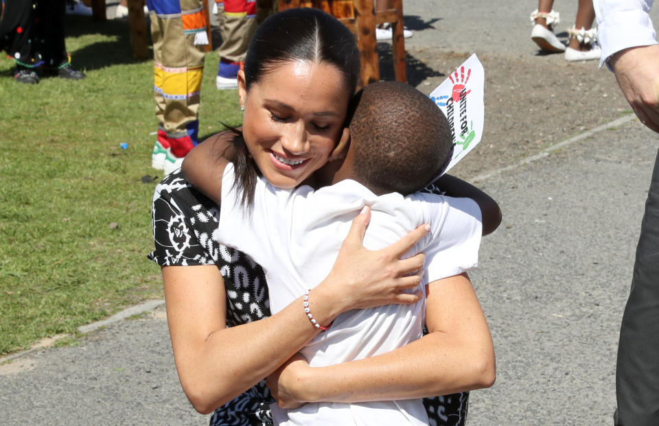 September 23, 2019: Meghan Markle receives a hug from a young well-wisher as she visit a Justice Desk initiative in Nyanga township with Prince Harry