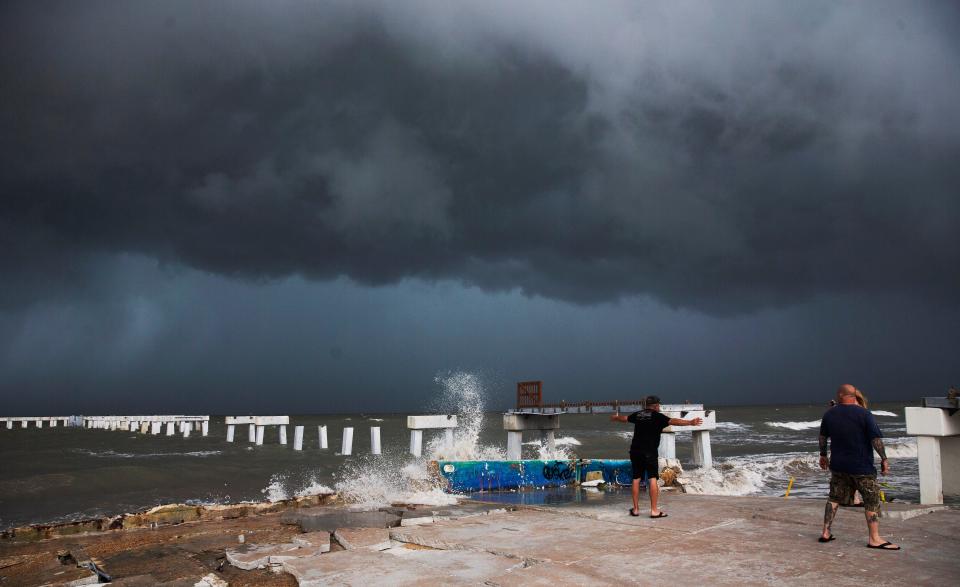 Beachgoers check out the surf as Hurricane Idalia approaches Florida at Times Square on Fort Myers Beach on Tuesday, Aug. 29, 2023.