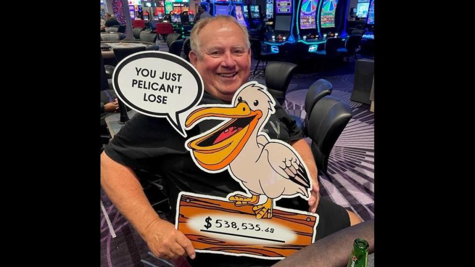 Allen S. of Canada grins as he holds a sign after he won more than half a million dollars on the Mississippi Stud table game at Harrah’s Gulf Coast in Biloxi.