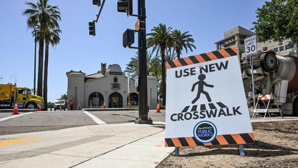 A sign points pedestrians to a new crosswalk near the Tulare Street Amtrak station and tracks at Tulare and R streets in downtown Fresno where construction is close to wrapping up on Monday, May 20, 2024. The crossing is at the center of a jaywalking incident that turned into a nightmare for a Fresno police officer.