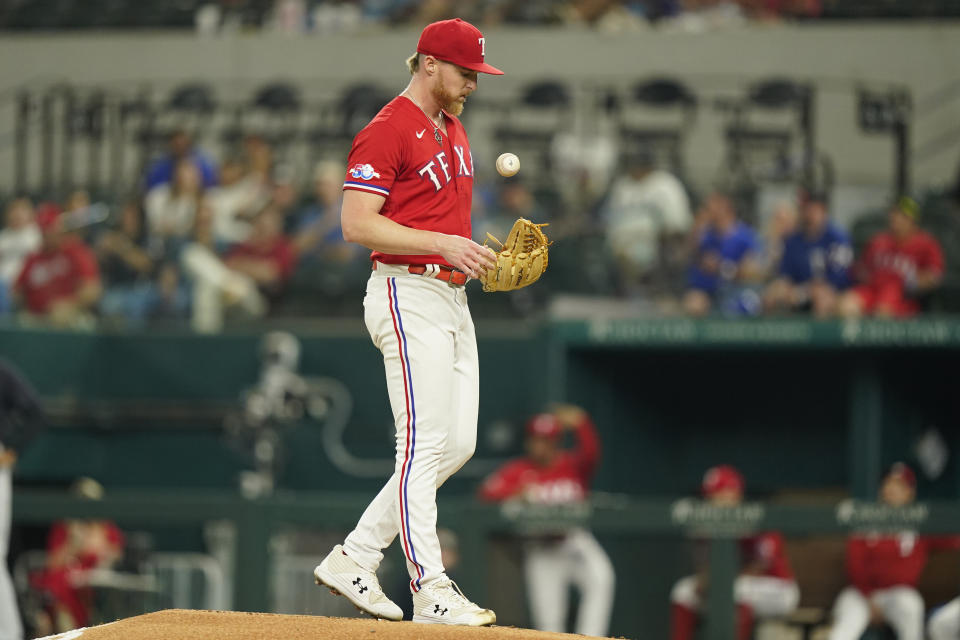 Texas Rangers starting pitcher Jon Gray tosses the ball on the mound during the second inning of a baseball game against the Cleveland Guardians in Arlington, Texas, Friday, Sept. 23, 2022. (AP Photo/LM Otero)