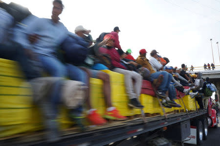 Migrants, part of a caravan of thousands traveling from Central America en route to the United States, ride on a truck, in Irapuato, Mexico November 12, 2018. REUTERS/Go Nakamura