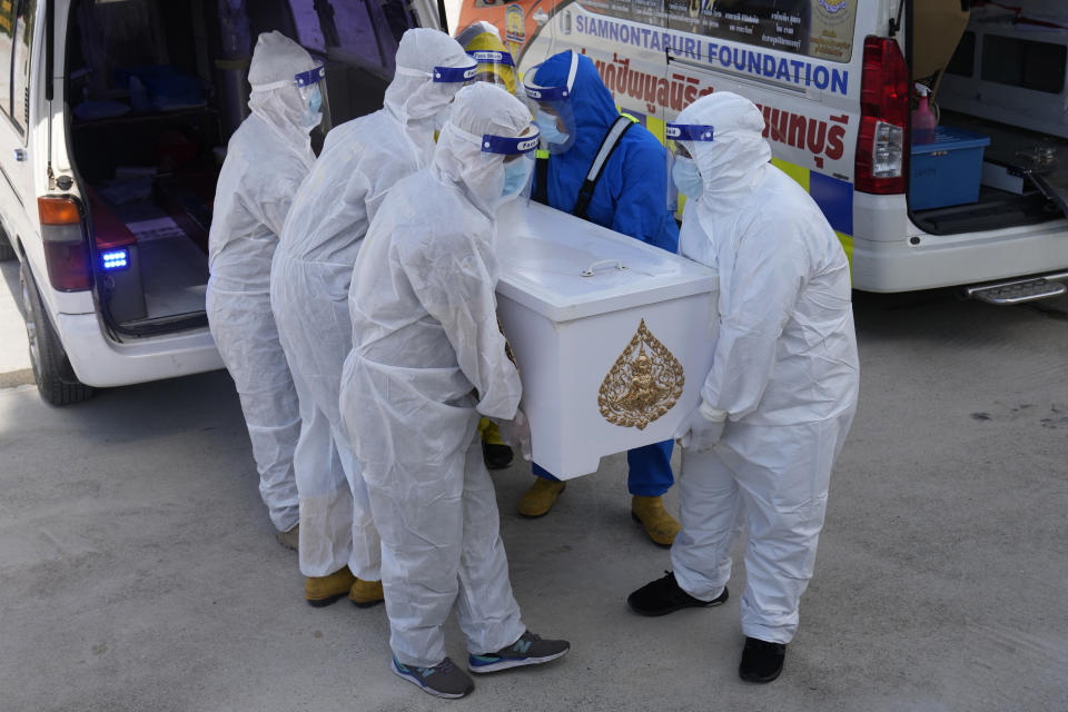 Siam Nonthaburi Foundation volunteers in full protective suits carrying coffin with a COVID-19 victim for a free funeral ceremony service at Wat Ratprakongtham temple Nonthaburi Province, Thailand, Monday, July 12, 2021. Wat Ratprakongtham temple offering free funeral service for people dying from COVID-19 says it is struggling to keep up with 24-hour cremation, and is adding another crematorium as Thailand sees a growing number of cases and deaths in a coronavirus surge that began in early April. (AP Photo/Sakchai Lalit)