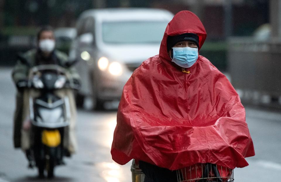 A man wearing a protective face mask commutes on a road as it rains in Shanghai on February 11, 2020. - The death toll from a new coronavirus outbreak surged past 1,000 on February 11 as the World Health Organization warned infected people who have not travelled to China could be the spark for a "bigger fire". (Photo by NOEL CELIS / AFP) (Photo by NOEL CELIS/AFP via Getty Images)