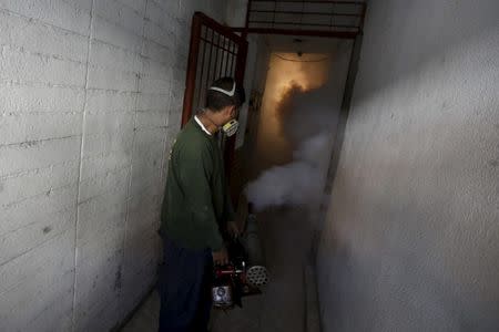 A municipal worker fumigates inside a building to help control the spread of the mosquito-borne Zika virus in Caracas, February 2, 2016. REUTERS/Marco Bello