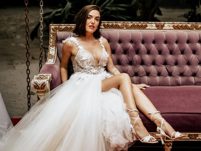 Thaina Bak poses in her wedding dress on a couch