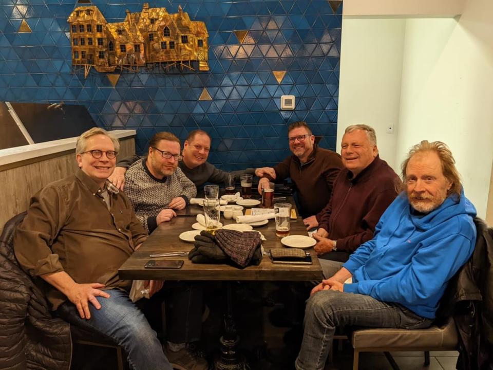 Teenage Head artist Gord Lewis, far right in the blue sweater, sits with family members, including his son Jonathan, middle left in the grey sweater. Jonathan is facing a second-degree murder charge in the August death of his father. (Submitted by Brian Lewis - image credit)