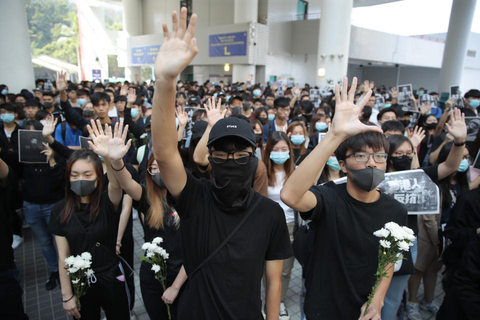 Protesters hold up their hands to represent their five demands during a makeshift memorial for Chow Tsz-Lok at the University of Science and Technology in Hong Kong on Friday, Nov. 8, 2019. Chow, a student from the University who fell off a parking garage after police fired tear gas during clashes with anti-government protesters died Friday, in a rare fatality after five months of unrest that intensified anger in the semi-autonomous Chinese territory. (AP Photo/Kin Cheung)