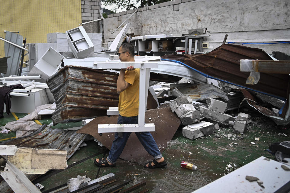In this photo provided by China's Xinhua News Agency,In this photo released by Xinhua News Agency, a man removes debris from a damaged building in the aftermath of a tornado in Guangming Village of Zhongluotan Town, Baiyun District, Guangzhou, south China's Guangdong Province, Sunday, April 28, 2024. Aerial photos posted by Chinese state media on Sunday showed the wide devastation of a part of the southern city of Guangzhou after a tornado swept through the day before, killing and injuring dozens of people and damaging over a hundred buildings. (Deng Hua/Xinhua via AP)