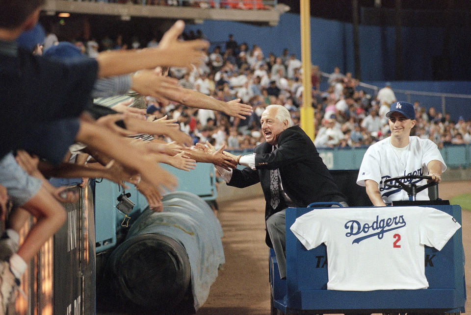 FILE - Former Los Angeles Dodgers manager Tommy Lasorda laughs as he reaches out for fans' hands on as he is driven around Dodger Stadium in Los Angeles for a farewell lap following a ceremony in his honor, in this Friday, Sept. 7, 1996, file photo. Lasorda, who guided the Los Angeles Dodgers to two World Series titles and later became an ambassador for the sport he loved during his 71 years with the franchise, has died. He was 93. The Dodgers said Friday, Jan. 8, 2021, that he had a heart attack at his home in Fullerton, California. Resuscitation attempts were made on the way to a hospital, where he was pronounced dead shortly before 11 p.m. Thursday. (AP Photo/Susan Sterner, File)