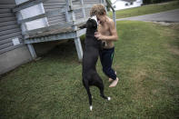 Donovyn Bonice, 8, plays with his dog, Delilah, on his family's back porch in Bidwell, Ohio, on Monday, July 27, 2020. His mother, Tasha Lamm, 30, is raising her two sons on public assistance. (AP Photo/Wong Maye-E)