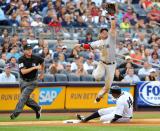 Curtis Granderson #14 of the New York Yankees slides safely under third baseman Nick Punto #5 of the Boston Red Sox as he jumps to catch a high throw in the seventh inning at Yankee Stadium on August 18, 2012 in the Bronx borough of New York City. (Photo by Jason Szenes/Getty Images)