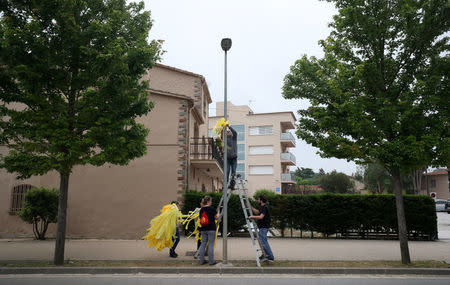 Members of Granoller's Committee for the Defence of the Republic (CDR) hang yellow ribbons to demand the release of jailed Catalonian politicians in Granollers, Spain May 12, 2018. REUTERS/Albert Gea