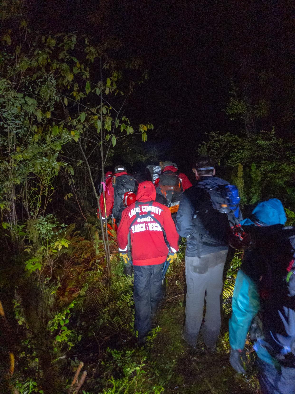 Lane County Search and Rescue Team personnel stabilize a woman found near Herman Peak Road northeast of Florence.