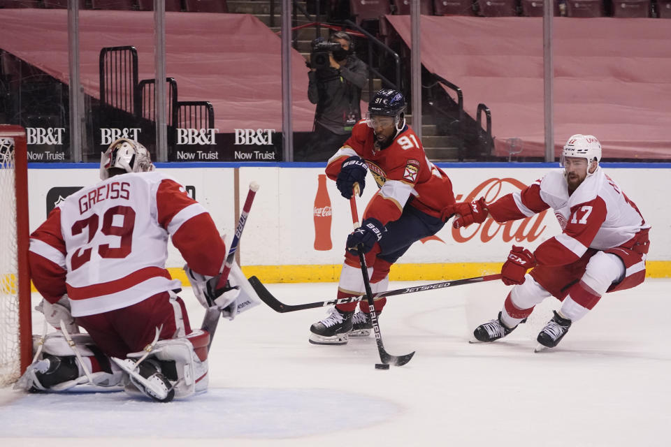 Florida Panthers left wing Anthony Duclair (91) attempts a shot against Detroit Red Wings goaltender Thomas Greiss (29) and defenseman Filip Hronek (17) during the second period of an NHL hockey game, Sunday, Feb. 7, 2021, in Sunrise, Fla. (AP Photo/Wilfredo Lee)