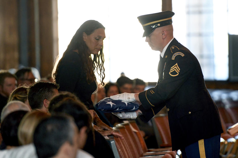 Natalie Henry-Howell, mother of Riley Howell, receives his flag from a military honor guard during a memorial service for Riley Howell in Lake Junaluska, N.C., Sunday, May 5, 2019. Family and hundreds of friends and neighbors are remembering Howell, a North Carolina college student credited with saving classmates' lives by rushing a gunman firing inside their lecture hall. (AP Photo/Kathy Kmonicek)