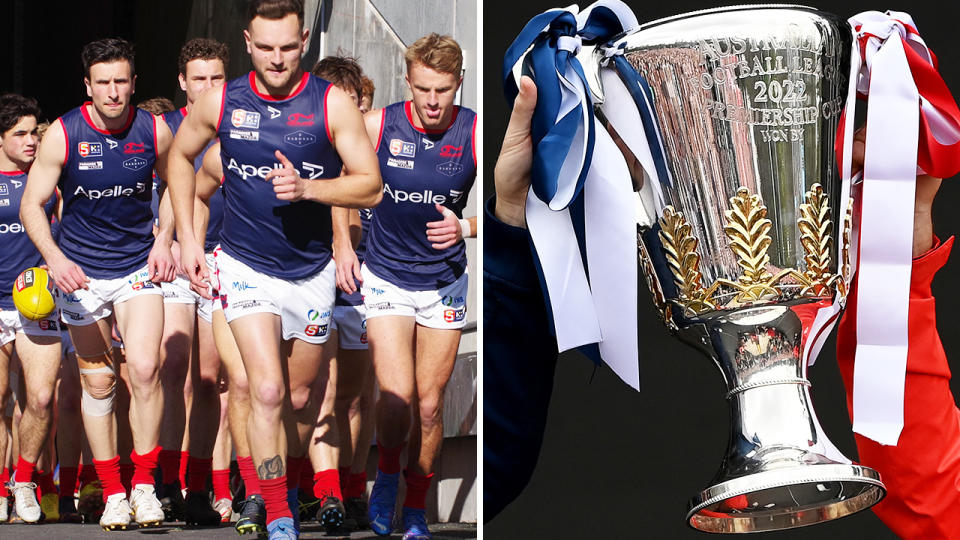 Norwood players emerge from the race on the left, with the AFL premiership cup seen right.