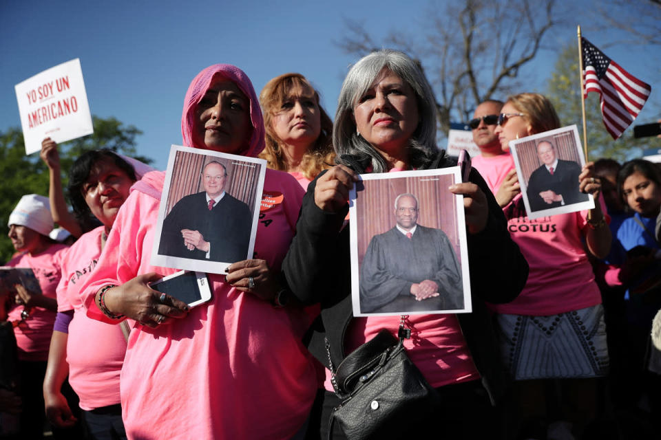 Activists hold portraits of Supreme Court justices