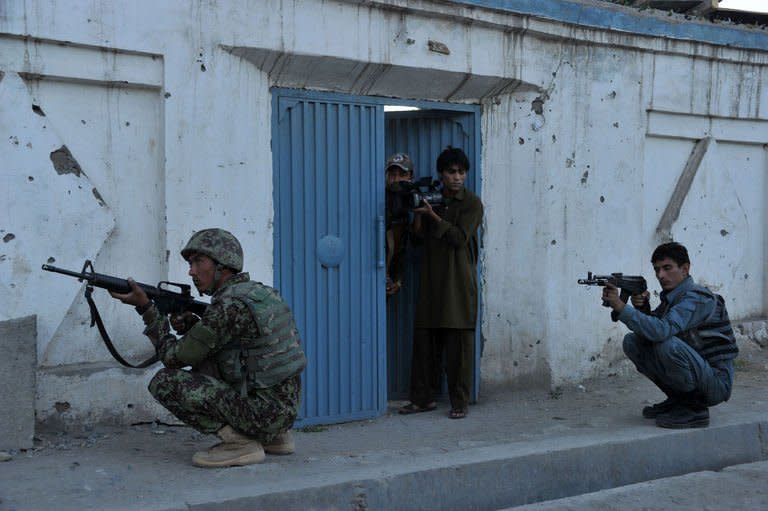 Afghan security personnel train their weapons on the scene of an attack in Jalalabad on May 29, 2013. The Taliban on Friday denied any involvement in a deadly suicide attack on International Committee of the Red Cross offices that prompted the organisation to halt staff movement across Afghanistan