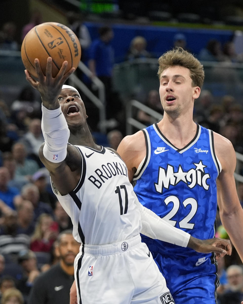 Brooklyn Nets guard Dennis Schroder (17) shoots after getting past Orlando Magic forward Franz Wagner (22) during the first half of an NBA basketball game Wednesday, March 13, 2024, in Orlando, Fla. (AP Photo/John Raoux)