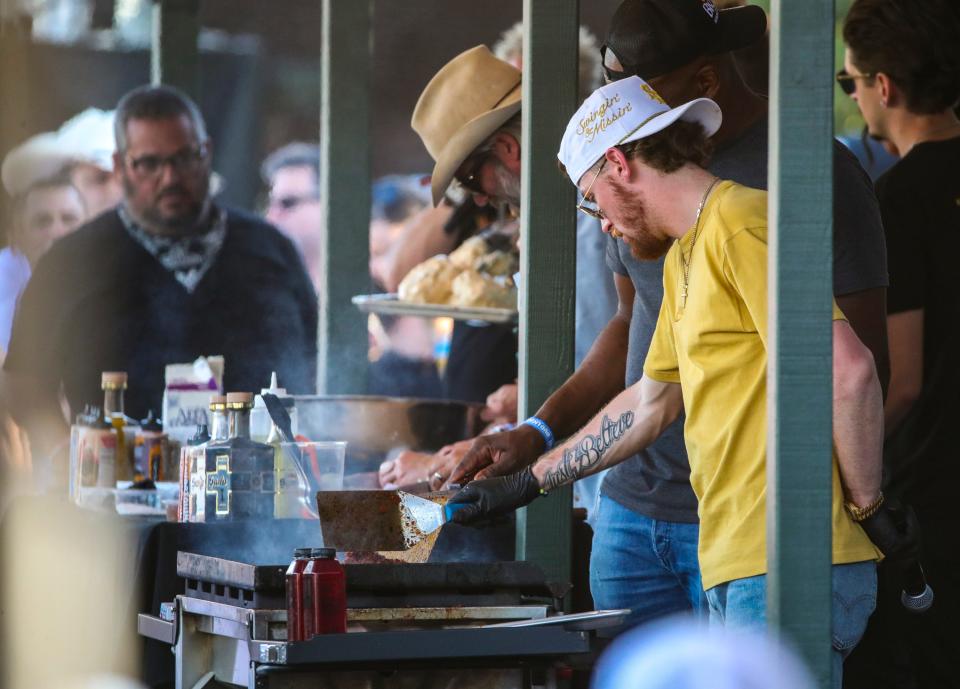 Bailey Zimmerman works the grill during a cooking demonstration with Guy Fieri and Hardy at Guy Fieri's Smokehouse during Stagecoach country music festival in Indio, Calif., Sunday, April 28, 2024.