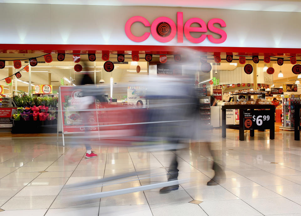 A shopper walks out of Coles supermarket.
