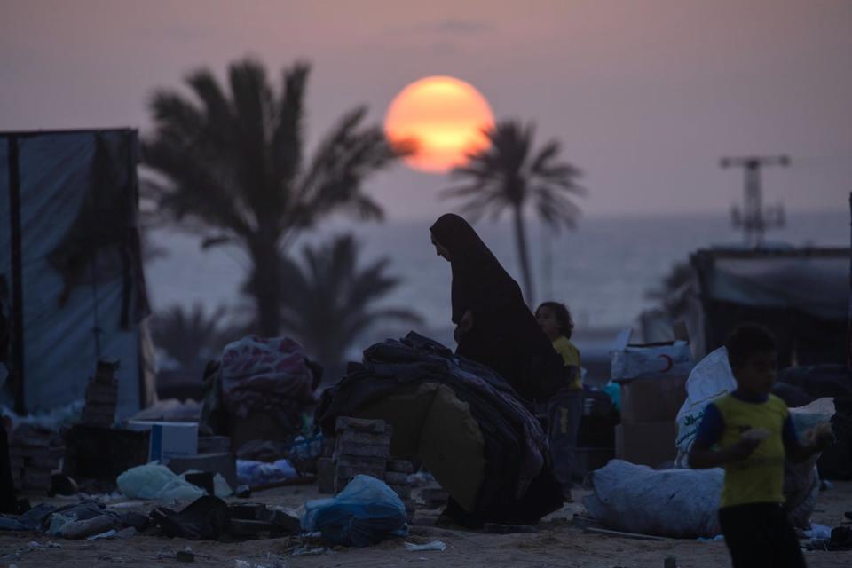 Displaced Palestinians prepare to leave with their belongings (EPA)