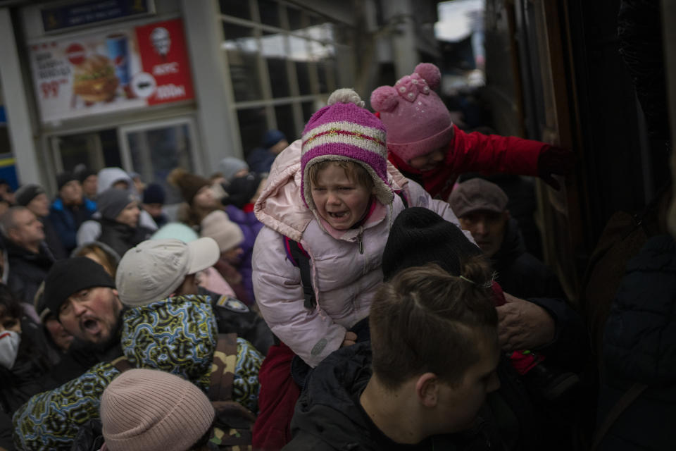 People holding their children struggle to get on a train to Lviv at the Kyiv station, Ukraine, Monday, March 7, 2022. Russia announced yet another cease-fire and a handful of humanitarian corridors to allow civilians to flee Ukraine. Previous such measures have fallen apart and Moscow's armed forces continued to pummel some Ukrainian cities with rockets Monday. (AP Photo/Emilio Morenatti)