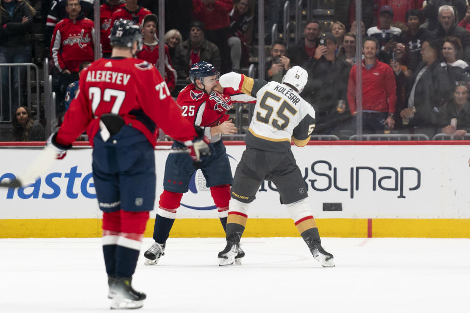 Washington Capitals defenseman Dylan McIlrath (25) and Vegas Golden Knights right wing Keegan Kolesar (55) scuffle in the first period of an NHL hockey game, Tuesday, Nov. 14, 2023, in Washington. (AP Photo/Stephanie Scarbrough)