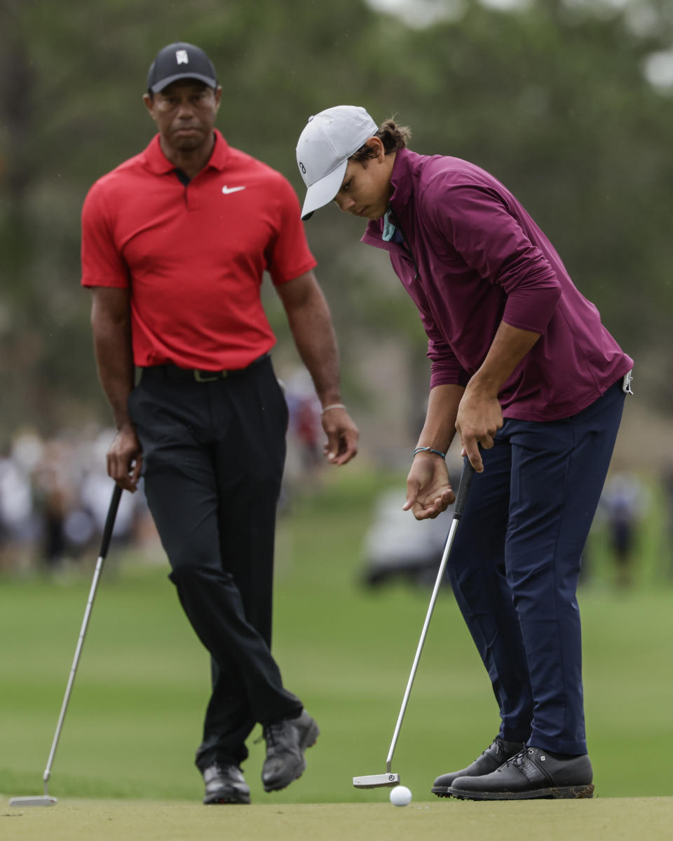 Tiger Woods, left, watches his son Charlie, right, putt ball during the final round of the PNC Championship golf tournament Sunday, Dec. 17, 2023, in Orlando, Fla. (AP Photo/Kevin Kolczynski)