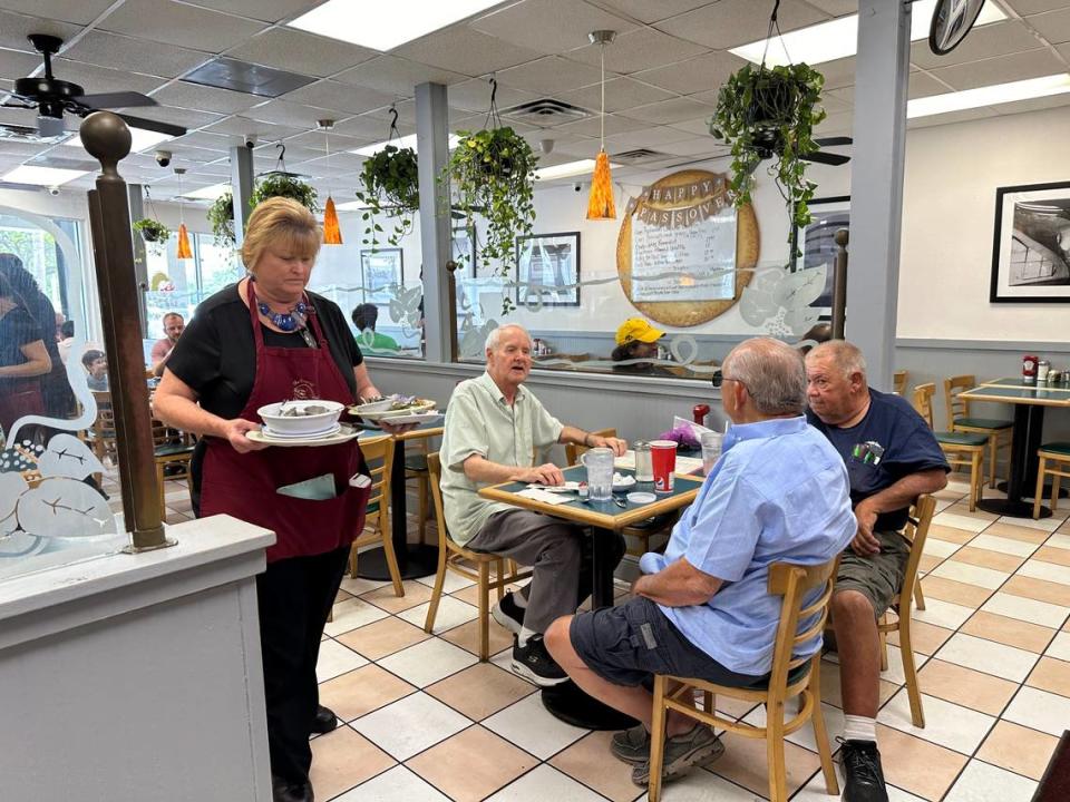 Tonya Gay has worked at Lots of Lox in Palmetto Bay for 26 years. Regular customers, like Mike Foster, left in green shirt, come here for the food, service and daily conversations on all sorts of topics. They are seen here as the afternoon comes to a close near 3 p.m. on April 24, 2024. Howard Cohen/hcohen@miamiherald.com