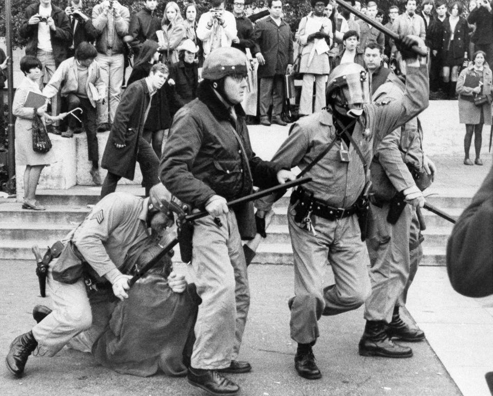 Helmeted police drive student militants back trying to rescue a fallen demonstrator in one of running clashes on the University of California campus in Berkeley on Feb. 19, 1969. It was the worst violence of a month-old strike where 200 officers chased demonstrators around the campus, arresting 25.