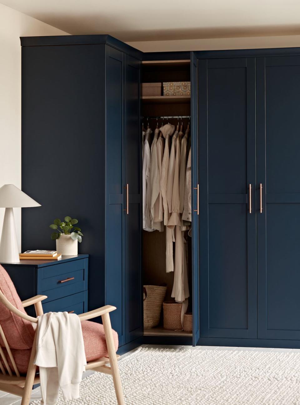 a bedroom with a blue fitted wardrobe and a chair